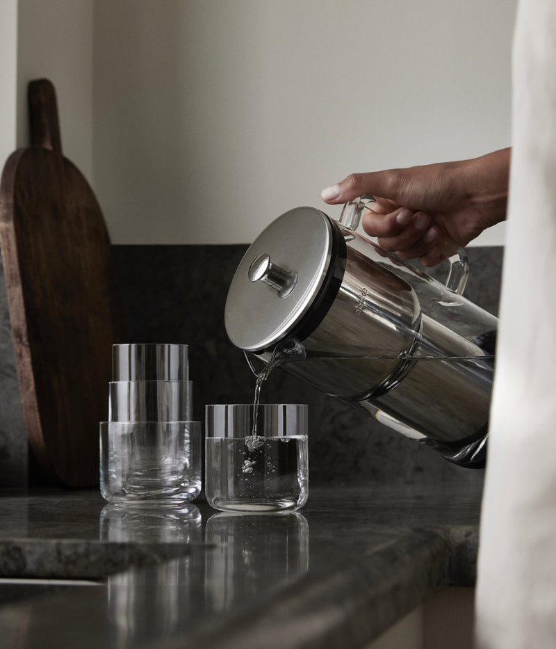 Purifier water filter pitcher pouring water into a glass