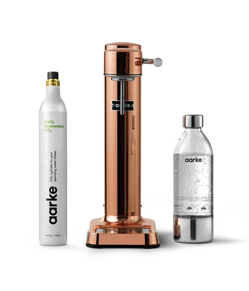 Front view of the Carbonator 3 in Copper beside a PET water bottle and 1 Aarke CO2 Cylinder.