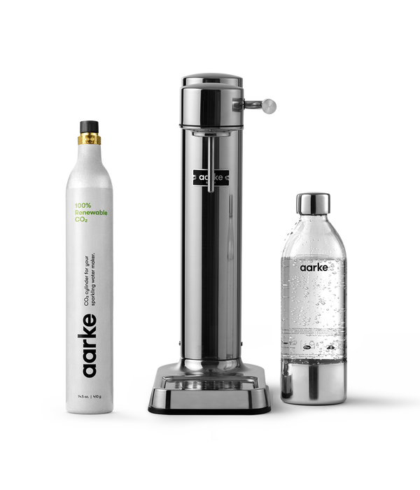 Front view of the Carbonator 3 in Stainless Steel beside a PET water bottle and 1 Aarke CO2 Cylinder.